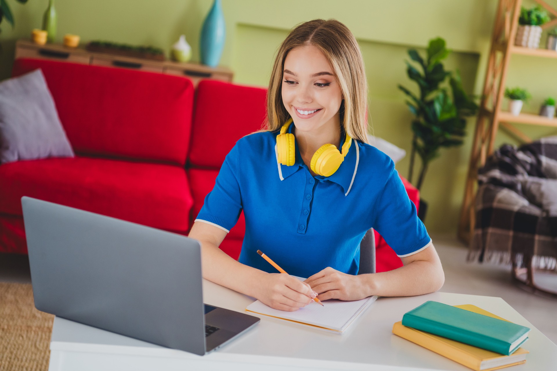 Photo of blonde teenager woman remote study elearning netbook write notebook dressed blue outfit cozy day light home interior living room
